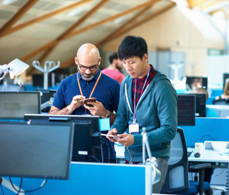 Two colleagues in a room with a lot of computers